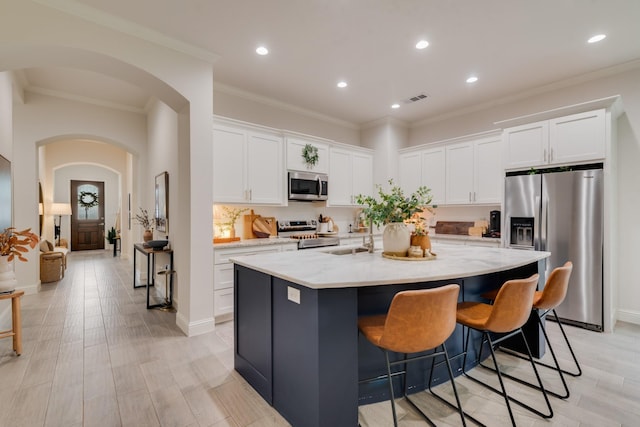 391 E Lamar St, Royse City, TX 75189 - kitchen with stainless steel appliances, arched walkways, a sink, recessed lighting, and a kitchen island with sink