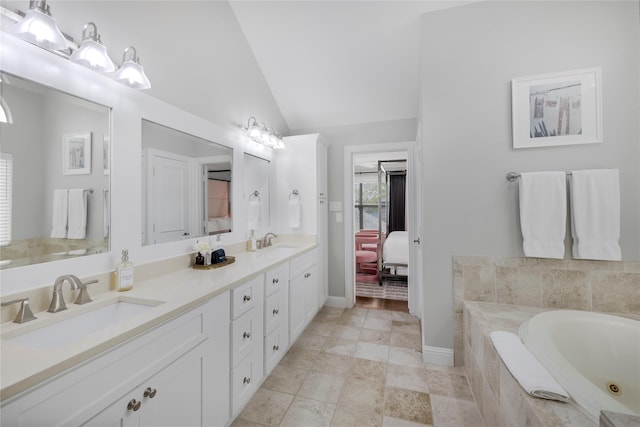 full bathroom with vaulted ceiling, a bath, double vanity, connected bathroom, and baseboards