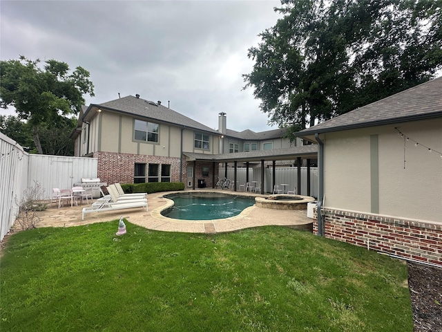 rear view of house featuring a patio area, stucco siding, a pool with connected hot tub, and brick siding
