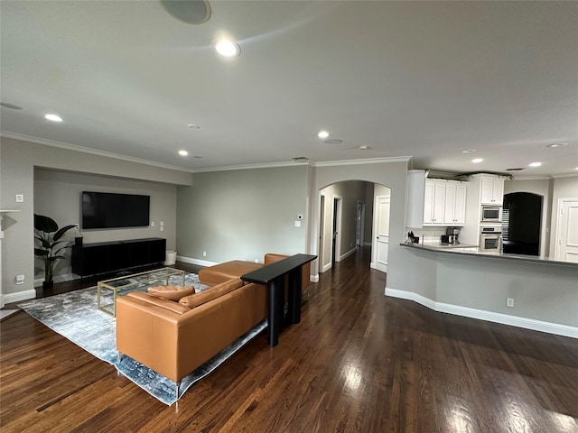 living area featuring arched walkways, baseboards, ornamental molding, dark wood-style floors, and recessed lighting