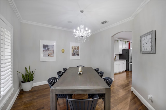 dining space featuring a chandelier, dark wood-style flooring, crown molding, arched walkways, and baseboards