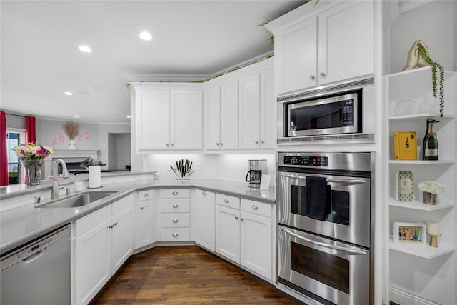 kitchen featuring stainless steel appliances, a sink, recessed lighting, light countertops, and white cabinets