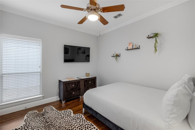bedroom featuring crown molding, wood finished floors, baseboards, and a ceiling fan