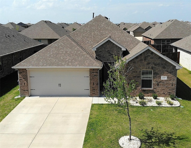 706 Spur Rdg, Princeton, TX 75407 - view of front of property featuring a shingled roof, a garage, a front yard, brick siding, and driveway