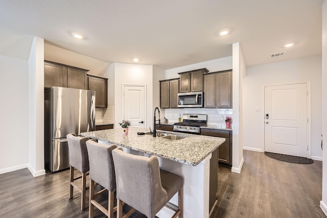 706 Spur Rdg, Princeton, TX 75407 - kitchen featuring appliances with stainless steel finishes, a sink, a center island with sink, dark brown cabinets, and decorative backsplash