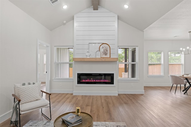 2104 Danner St, Fort Worth, TX 76105 - living room featuring wood finished floors, baseboards, lofted ceiling, a glass covered fireplace, and a chandelier