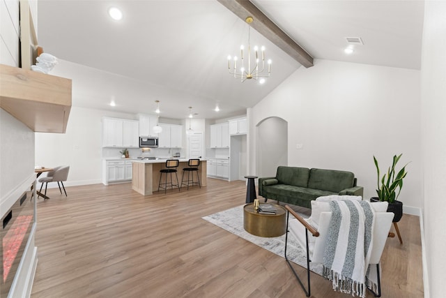 2104 Danner St, Fort Worth, TX 76105 - living room with a chandelier, recessed lighting, light wood-style floors, baseboards, and arched walkways