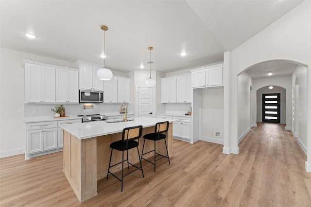 2104 Danner St, Fort Worth, TX 76105 - kitchen featuring stainless steel appliances, a sink, arched walkways, white cabinets, and recessed lighting