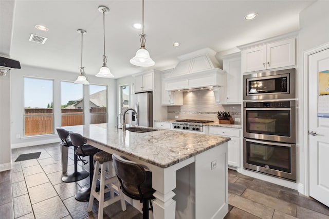 9521 Excursion Dr, Oak Point, TX 75068 - kitchen with stainless steel appliances, premium range hood, backsplash, recessed lighting, and white cabinetry