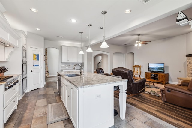 9521 Excursion Dr, Oak Point, TX 75068 - kitchen with a sink, arched walkways, open floor plan, a kitchen breakfast bar, and recessed lighting