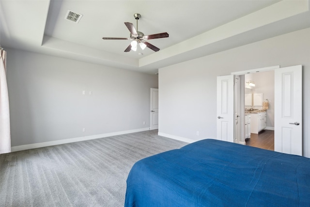 9521 Excursion Dr, Oak Point, TX 75068 - bedroom featuring a tray ceiling, baseboards, connected bathroom, and a ceiling fan