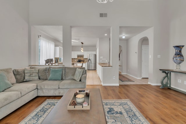 6813 Andress Dr, Fort Worth, TX 76132 - living area featuring arched walkways, light wood finished floors, and baseboards
