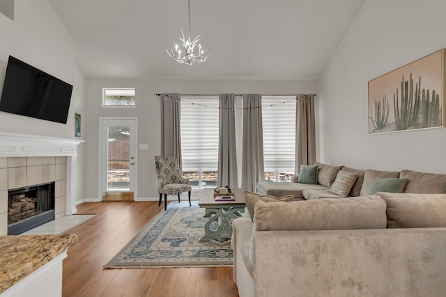 6813 Andress Dr, Fort Worth, TX 76132 - living room with a chandelier, wood finished floors, a tiled fireplace, and high vaulted ceiling