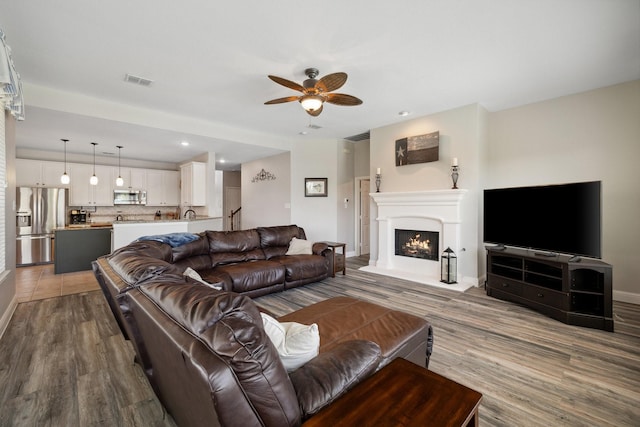 5136 Raisintree Dr, Fort Worth, TX 76244 - living room with ceiling fan, wood finished floors, baseboards, a lit fireplace, and recessed lighting