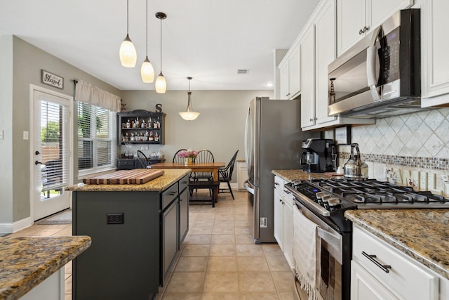 5136 Raisintree Dr, Fort Worth, TX 76244 - kitchen featuring appliances with stainless steel finishes, tasteful backsplash, white cabinets, a center island, and light tile patterned floors
