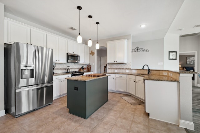 5136 Raisintree Dr, Fort Worth, TX 76244 - kitchen featuring appliances with stainless steel finishes, a peninsula, tasteful backsplash, dark stone countertops, and white cabinets
