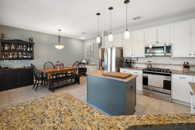 5136 Raisintree Dr, Fort Worth, TX 76244 - kitchen featuring appliances with stainless steel finishes, backsplash, white cabinetry, and light stone countertops