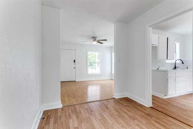 3109 S Wesleyan Dr, Fort Worth, TX 76105 - unfurnished room featuring light wood-style floors, a sink, ceiling fan, and baseboards