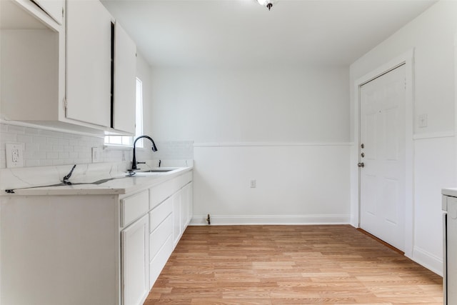 3109 S Wesleyan Dr, Fort Worth, TX 76105 - kitchen with a sink, light wood finished floors, light countertops, tasteful backsplash, and white cabinets