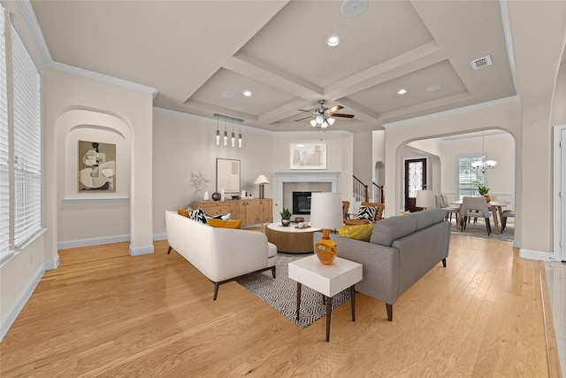7048 Fullerton Cir, Frisco, TX 75035 - living area featuring light wood finished floors, coffered ceiling, a glass covered fireplace, arched walkways, and baseboards