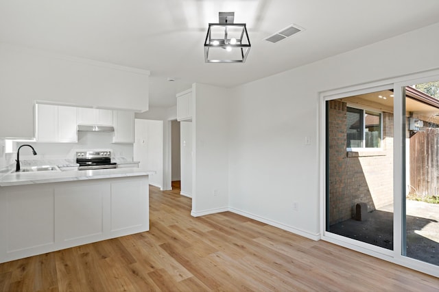 12816/12818 Pandora Dr, Dallas, TX 75238 - kitchen featuring stainless steel range with electric cooktop, a sink, under cabinet range hood, light wood-style floors, and white cabinetry