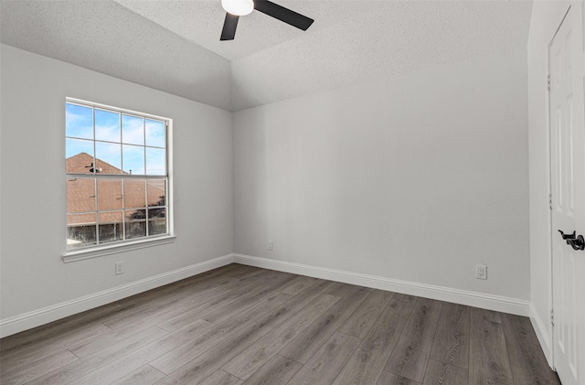 7129 Don Gomez Ln, Garland, TX 75043 - empty room featuring a ceiling fan, dark wood finished floors, a textured ceiling, vaulted ceiling, and baseboards