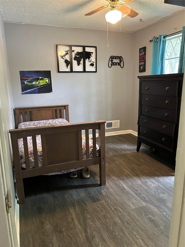 1024 W Chestnut St, Denison, TX 75020 - bedroom with wood finished floors, a textured ceiling, baseboards, and a ceiling fan
