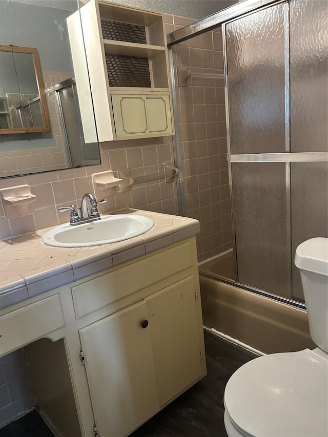 1024 W Chestnut St, Denison, TX 75020 - full bath with toilet, enclosed tub / shower combo, vanity, and decorative backsplash
