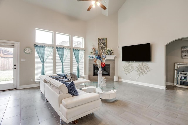 3015 Ruby Dr, Wylie, TX 75098 - living room with high vaulted ceiling, ceiling fan, arched walkways, a fireplace, and healthy amount of natural light