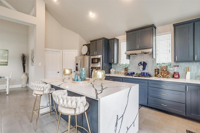 3015 Ruby Dr, Wylie, TX 75098 - kitchen featuring appliances with stainless steel finishes, tasteful backsplash, a kitchen bar, under cabinet range hood, and a center island