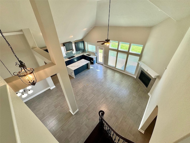 3015 Ruby Dr, Wylie, TX 75098 - unfurnished living room featuring a fireplace, high vaulted ceiling, wood finished floors, a ceiling fan, and baseboards