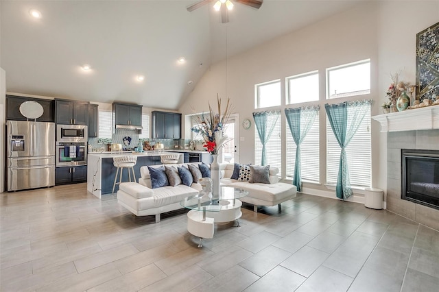 3015 Ruby Dr, Wylie, TX 75098 - living area with high vaulted ceiling, a ceiling fan, a tiled fireplace, and recessed lighting