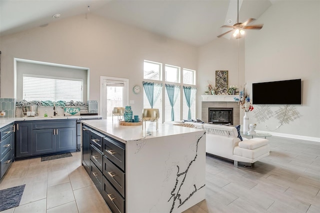 3015 Ruby Dr, Wylie, TX 75098 - kitchen featuring high vaulted ceiling, ceiling fan, a center island, healthy amount of natural light, and light stone counters
