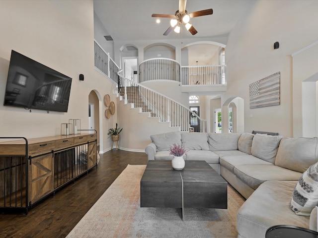 1505 Taylor Ln, Mckinney, TX 75071 - living room featuring ceiling fan, arched walkways, a high ceiling, stairs, and wood finished floors