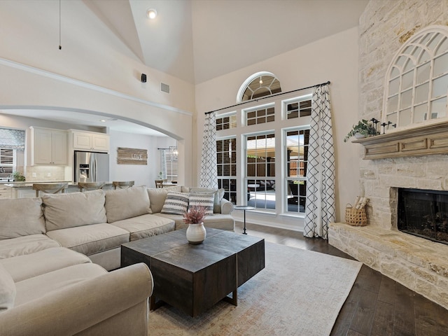1505 Taylor Ln, Mckinney, TX 75071 - living room with arched walkways, light wood finished floors, a fireplace, and high vaulted ceiling
