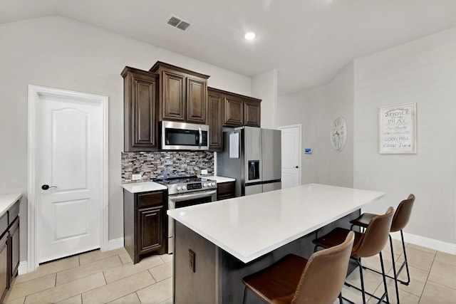 3817 Myrtle Way, Kaufman, TX 75142 - kitchen with stainless steel appliances, a kitchen bar, a center island, light countertops, and light tile patterned floors