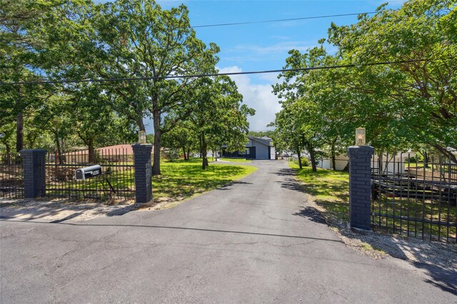 563 Country Club Rd, Bowie, TX 76230 - view of property hidden behind natural elements featuring a detached garage and a gate
