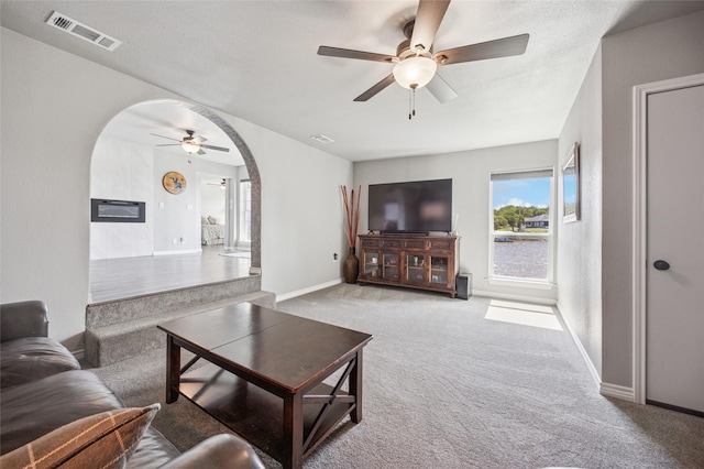563 Country Club Rd, Bowie, TX 76230 - living room with arched walkways, a ceiling fan, light carpet, and baseboards