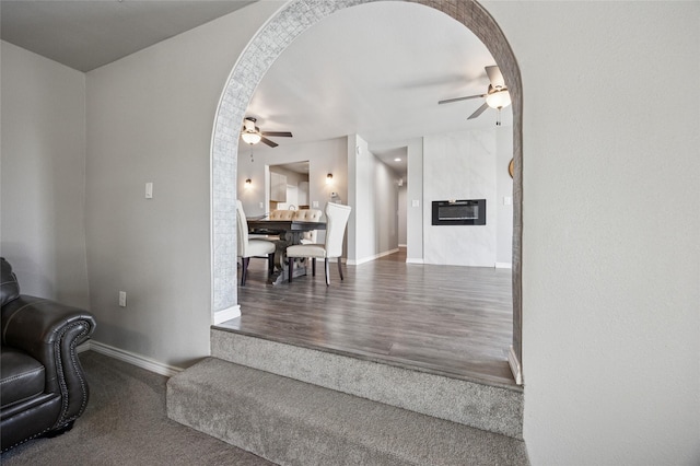 563 Country Club Rd, Bowie, TX 76230 - stairs featuring a ceiling fan, baseboards, arched walkways, and a large fireplace