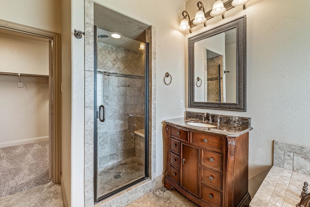 10601 San Simeon Ln, Fort Worth, TX 76179 - bathroom with a shower stall, vanity, a spacious closet, and baseboards