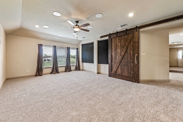 10601 San Simeon Ln, Fort Worth, TX 76179 - empty room with carpet, baseboards, ceiling fan, a barn door, and a textured ceiling