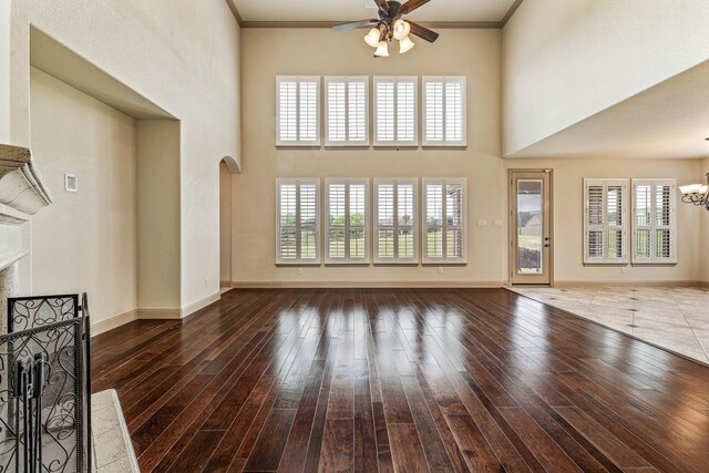 10601 San Simeon Ln, Fort Worth, TX 76179 - unfurnished living room with a ceiling fan, a fireplace, a chandelier, hardwood / wood-style floors, and arched walkways