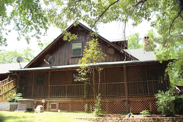 1147 Rs County Road 3503, Emory, TX 75440 - back of house with a sunroom, a chimney, central AC unit, and roof with shingles