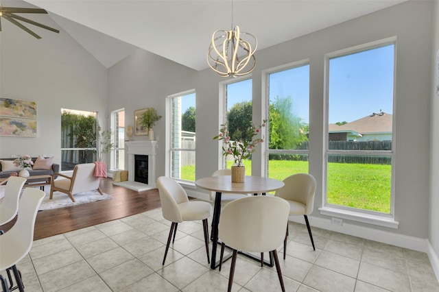 3925 Wisteria Ln, Haltom City, TX 76137 - dining area with healthy amount of natural light, a chandelier, light tile patterned flooring, and high vaulted ceiling
