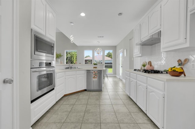 3925 Wisteria Ln, Haltom City, TX 76137 - kitchen featuring stainless steel appliances, under cabinet range hood, a peninsula, decorative backsplash, and white cabinets