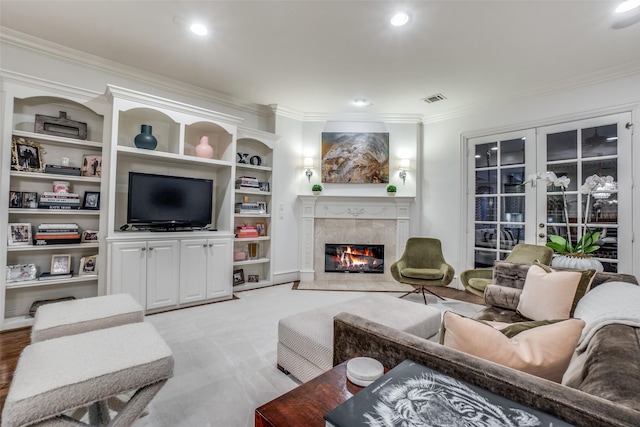 living area featuring ornamental molding, a fireplace, french doors, and recessed lighting