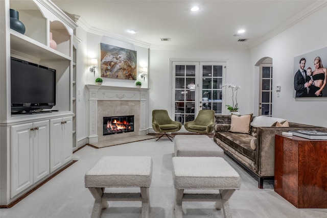 living area with ornamental molding, arched walkways, and a premium fireplace
