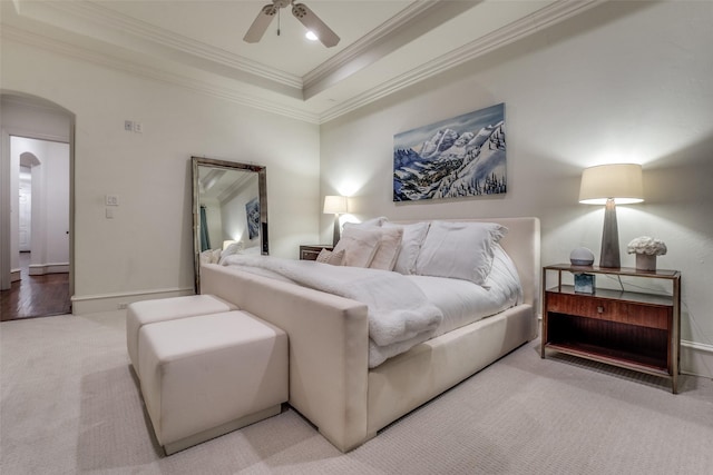 bedroom featuring carpet, arched walkways, ornamental molding, a ceiling fan, and baseboards