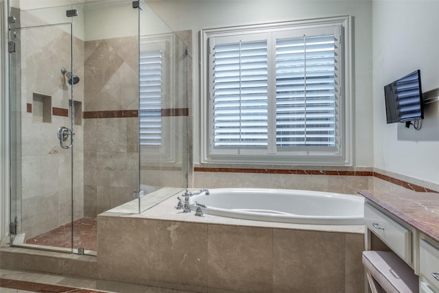 bathroom featuring a garden tub, a stall shower, and vanity