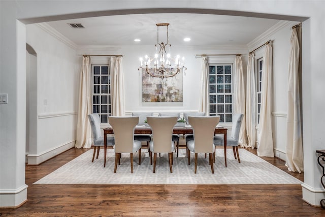 dining area featuring a chandelier, crown molding, wood finished floors, and recessed lighting